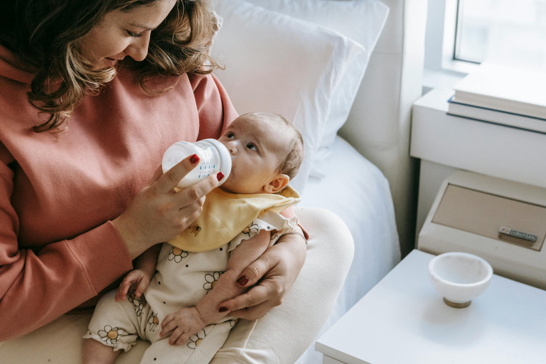 Mère, donnant le biberon à son enfant 